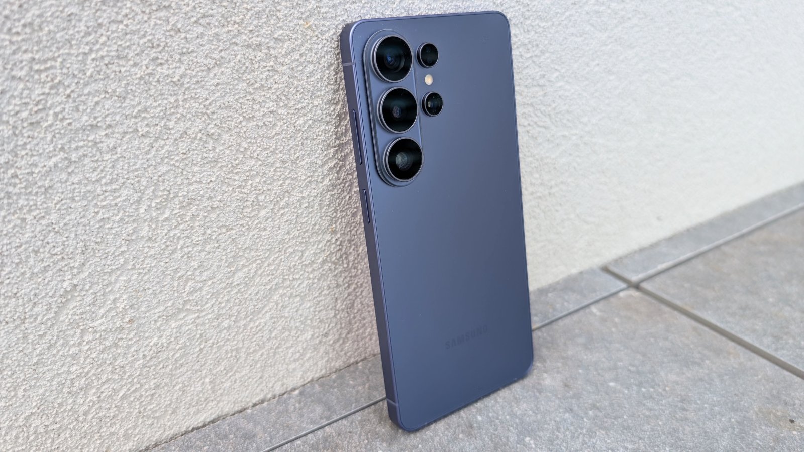 Galaxy S26 Ultra em violeta encostado em uma parede clara