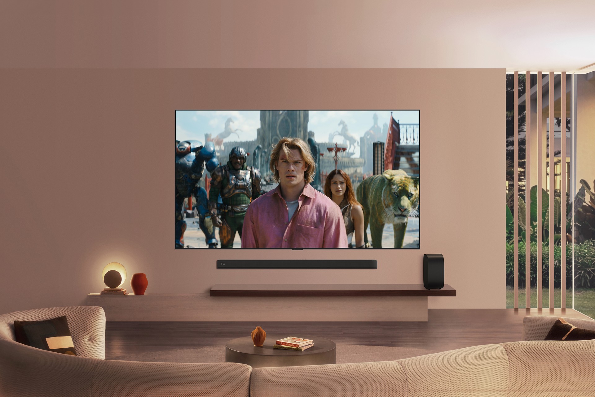 TV LG OLED exibindo cena da série Mestres do Universo, ao lado de uma soundbar