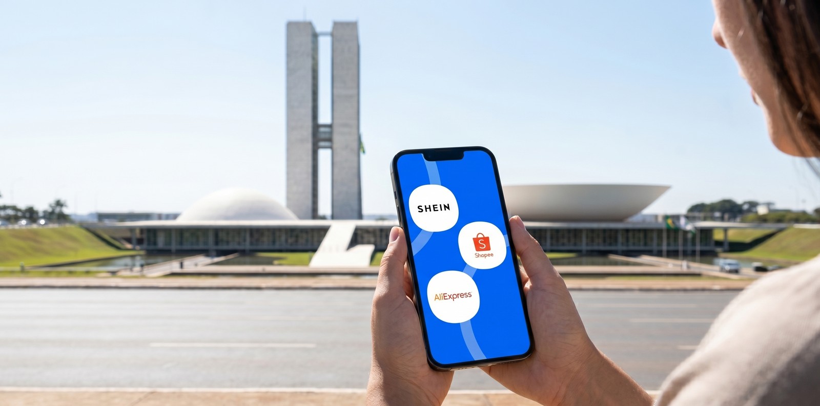 Celular com os apps da Shein, Shopee e AliExpress em frente ao Congresso Nacional