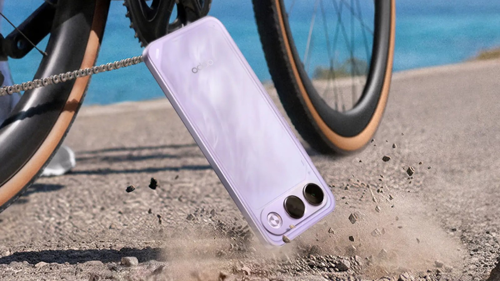 OPPO K15s caindo sobre o chão de terra ao lado de uma bicicleta