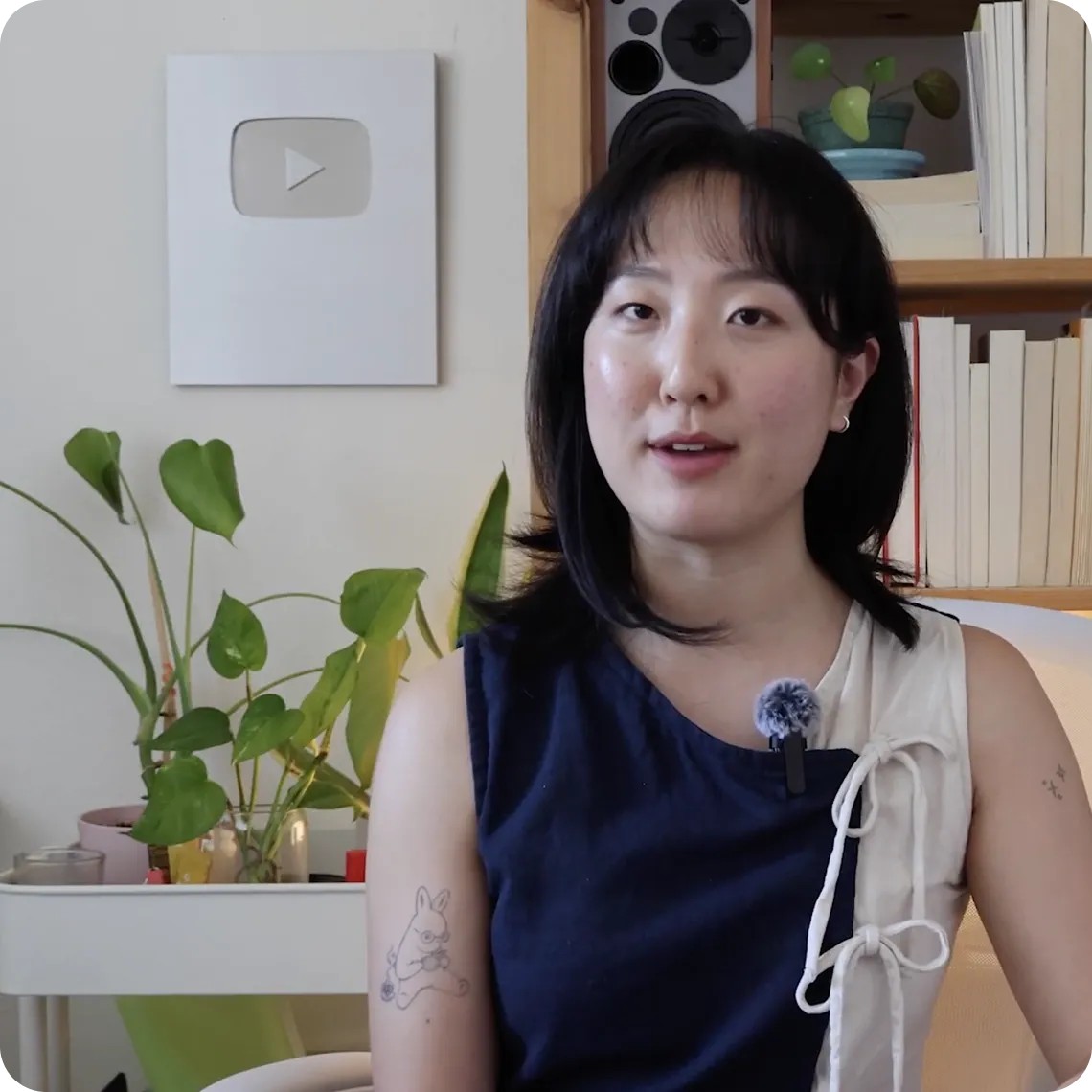 Criadora de conteúdo grava vídeo em casa, com placa de reconhecimento do YouTube na parede
